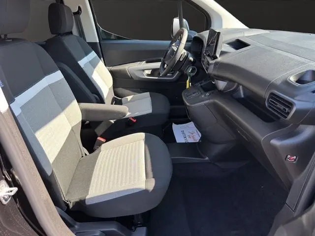 Intérieur avant du Citroën Berlingo noir 2025, sièges bicolores gris et noir, tableau de bord moderne avec volant multifonction.