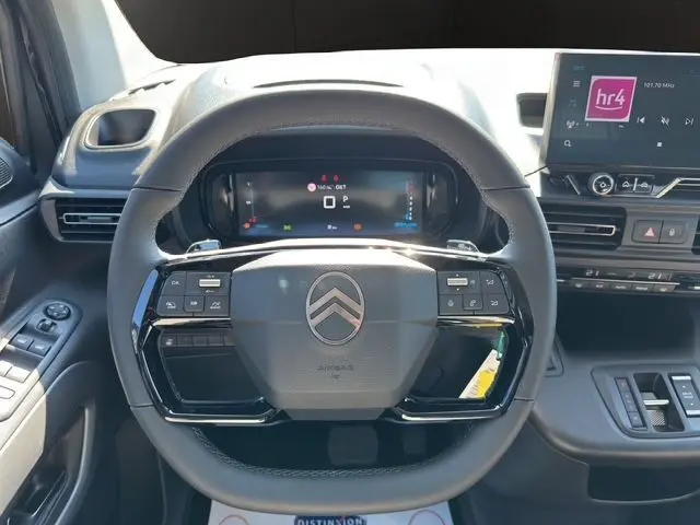 Vue rapprochée du volant noir du Citroën Berlingo 2025 avec commandes intégrées et écran digital derrière le volant.