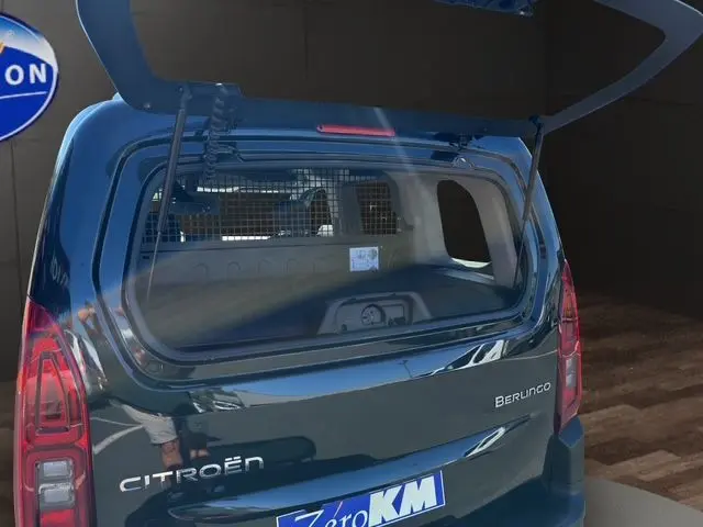 Vue arrière ouverte du Citroën Berlingo noir 2025, mettant en valeur la grille de séparation et la caméra de recul intégrée.
