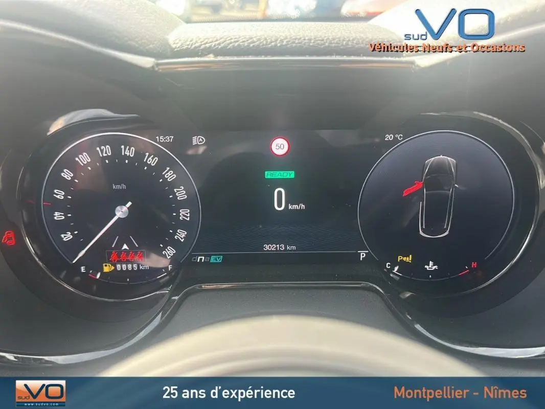 Tableau de bord numérique d'Alfa Romeo Tonale rouge 2024, affichage vitesse, température et alertes visibles.