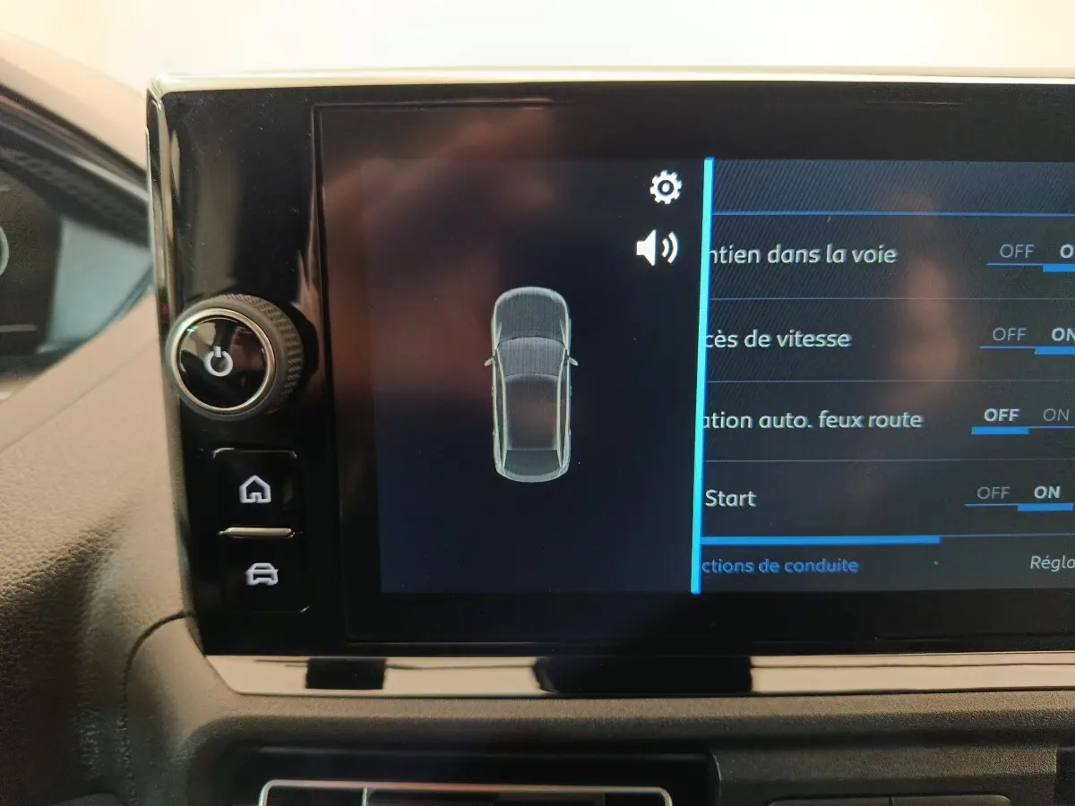 Écran tactile intérieur du Peugeot Partner blanc montrant les réglages d’aides à la conduite.
