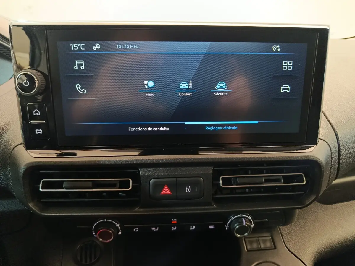 Écran tactile central du tableau de bord du Peugeot Partner blanc, avec commandes climatisation et alertes sécurité visibles.