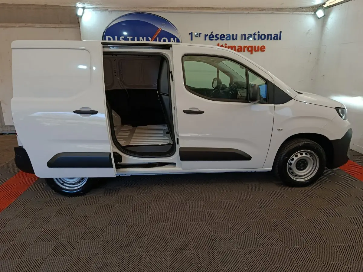 Vue latérale droite du Peugeot Partner blanc 2026 avec porte coulissante ouverte, montrant l'espace de chargement vide.