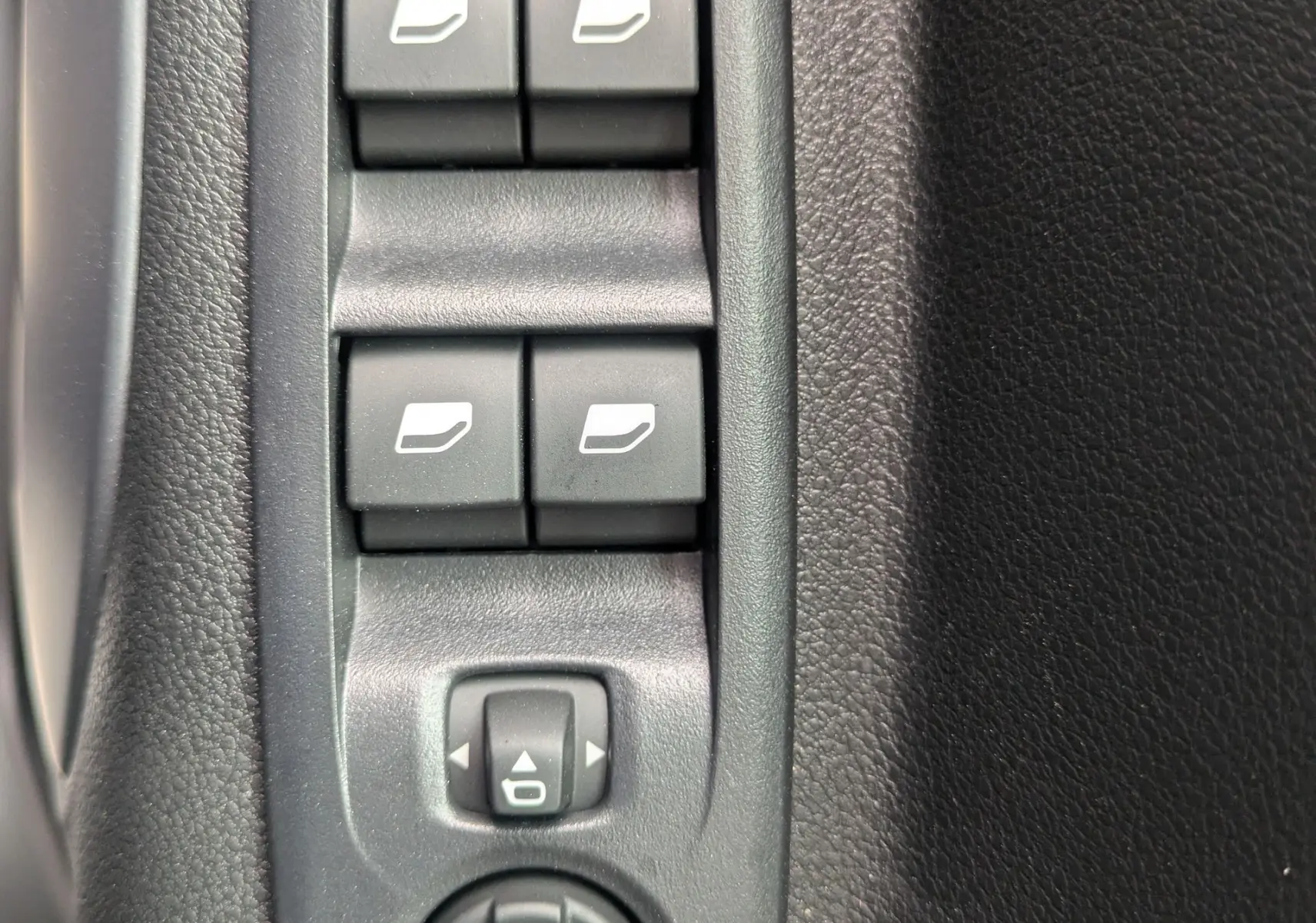Vue rapprochée des commandes de lève-vitres et réglage des rétroviseurs sur la porte intérieure noire du Citroën Berlingo blanc 2025.