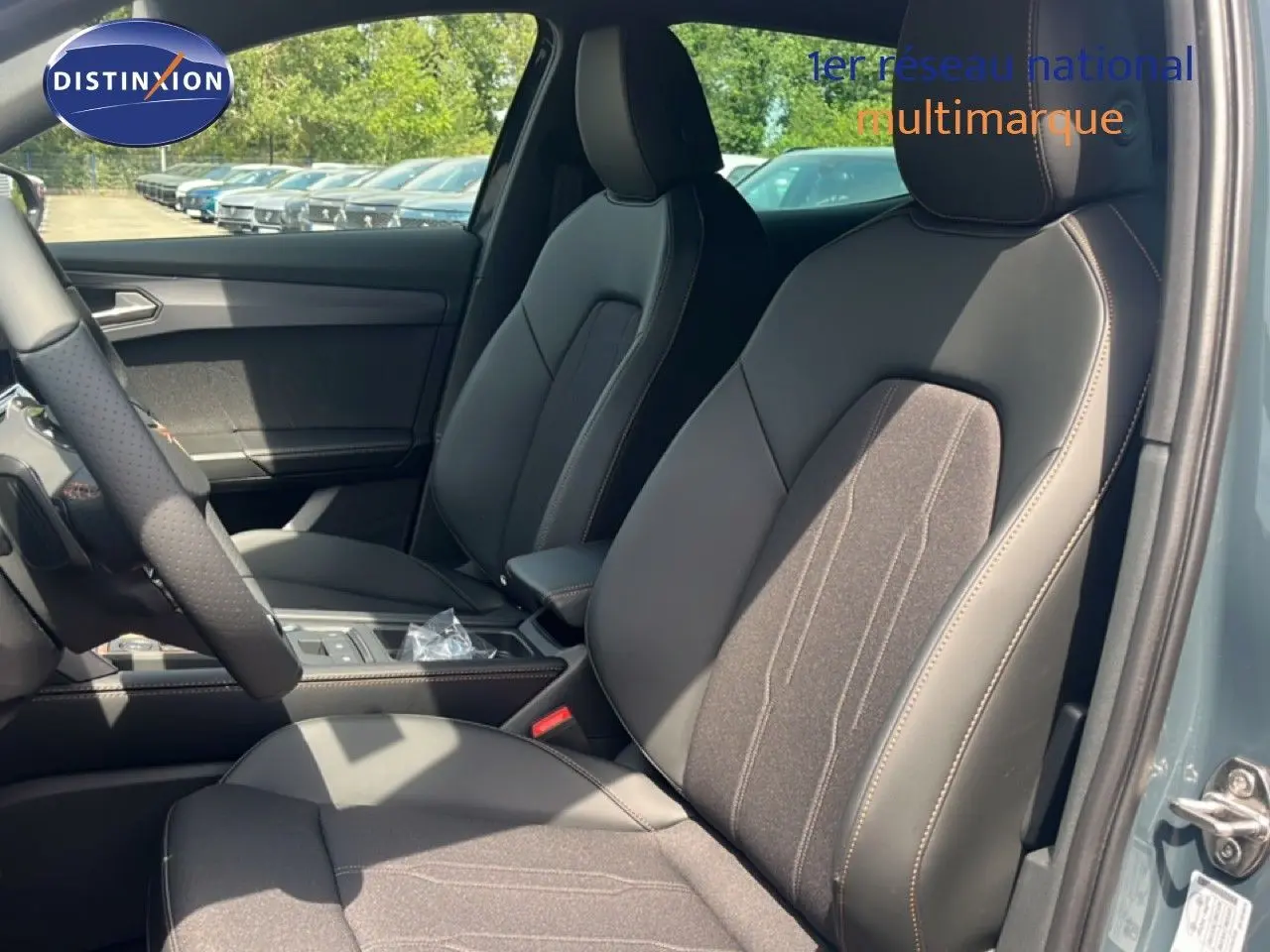 Vue intérieure côté conducteur de la CUPRA Formentor 1.5 eTSI 2026 avec sièges en cuir et tissu noir, portière bleu fjord visible.