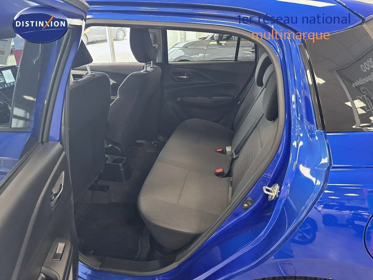 Vue intérieure côté gauche sur la banquette arrière d'une Suzuki Swift 1.2 Pack Hybrid bleu 2024 avec portes ouvertes.