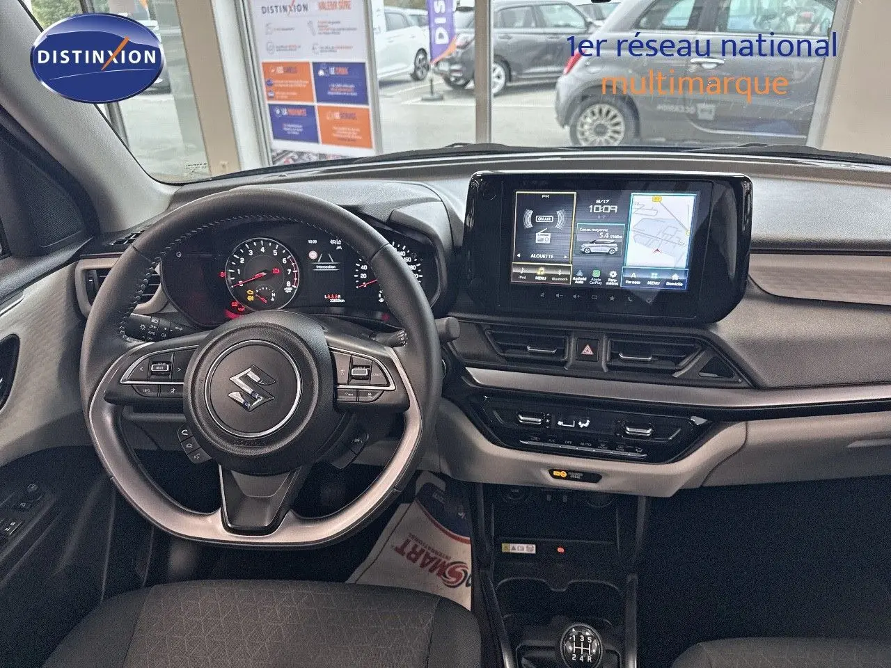 Vue intérieure du poste de conduite de la Suzuki Swift 1.2 Pack Hybrid 2024, avec volant multifonction et écran tactile central.