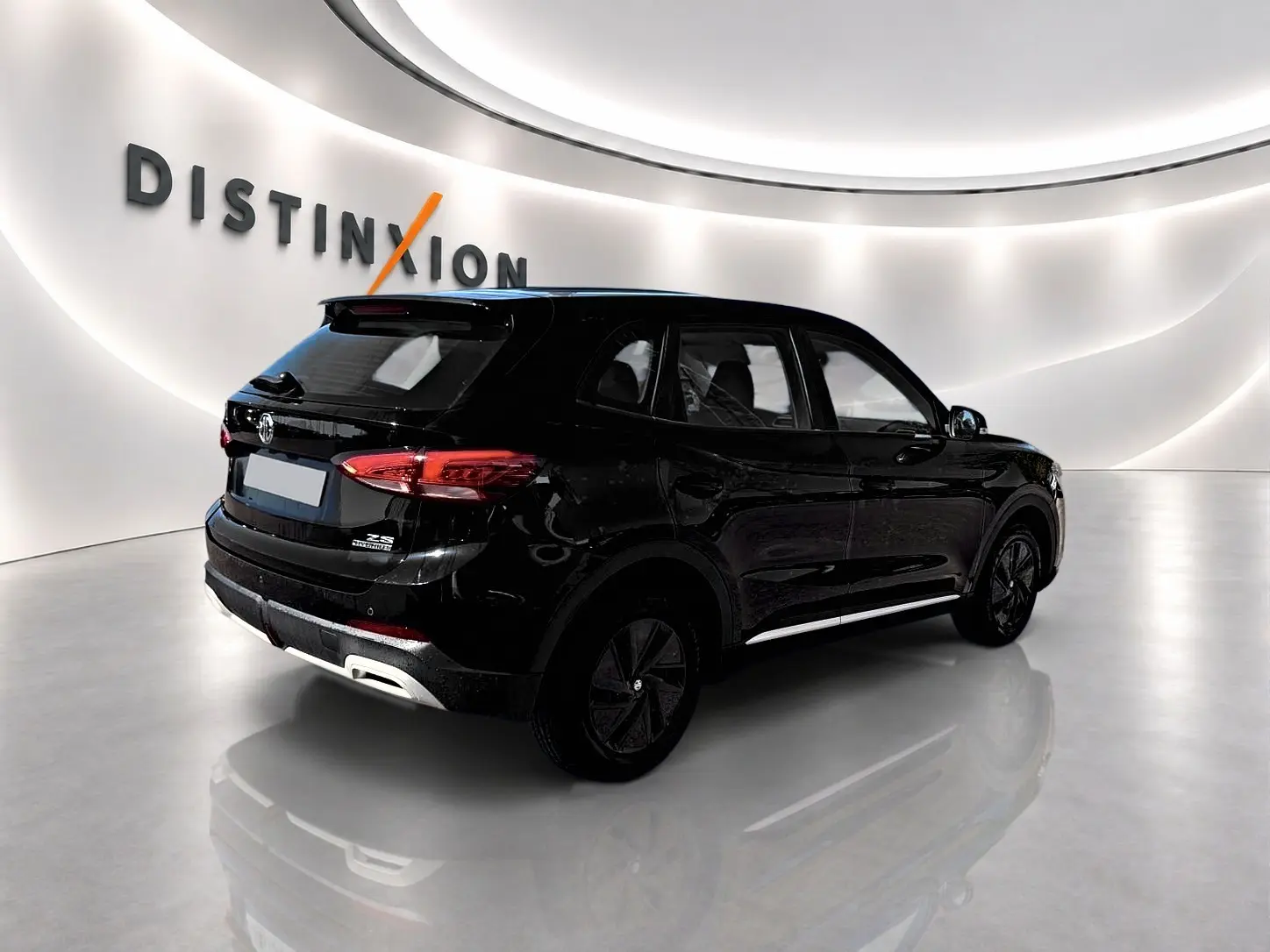 Vue 3/4 arrière droite d'un MG Motor ZS noir hybride 2026 avec feux arrière LED et becquet arrière.