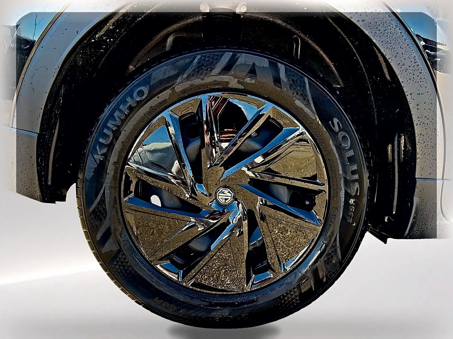 Gros plan sur la roue avant droite noire du MG ZS 1.5 hybrid 197 avec jante alliage brillante et logo MG central.