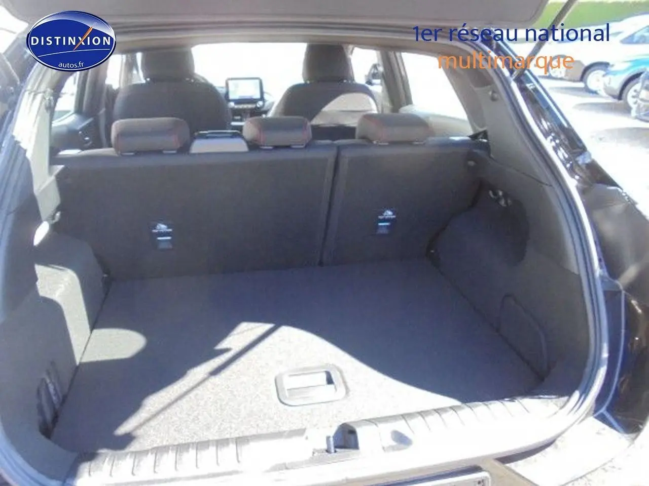 Coffre ouvert vu de l'arrière du Ford Puma noir 2022, montrant l'espace de chargement et les sièges arrière rabattables.