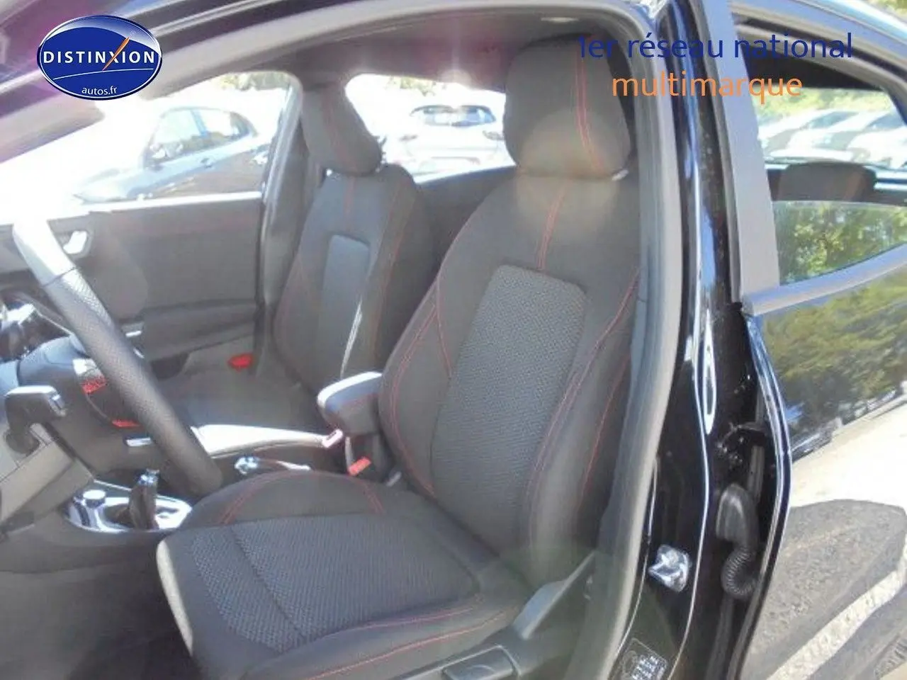 Vue intérieure côté conducteur du Ford Puma noir 2022 avec sièges en tissu noir et volant cuir multifonction.