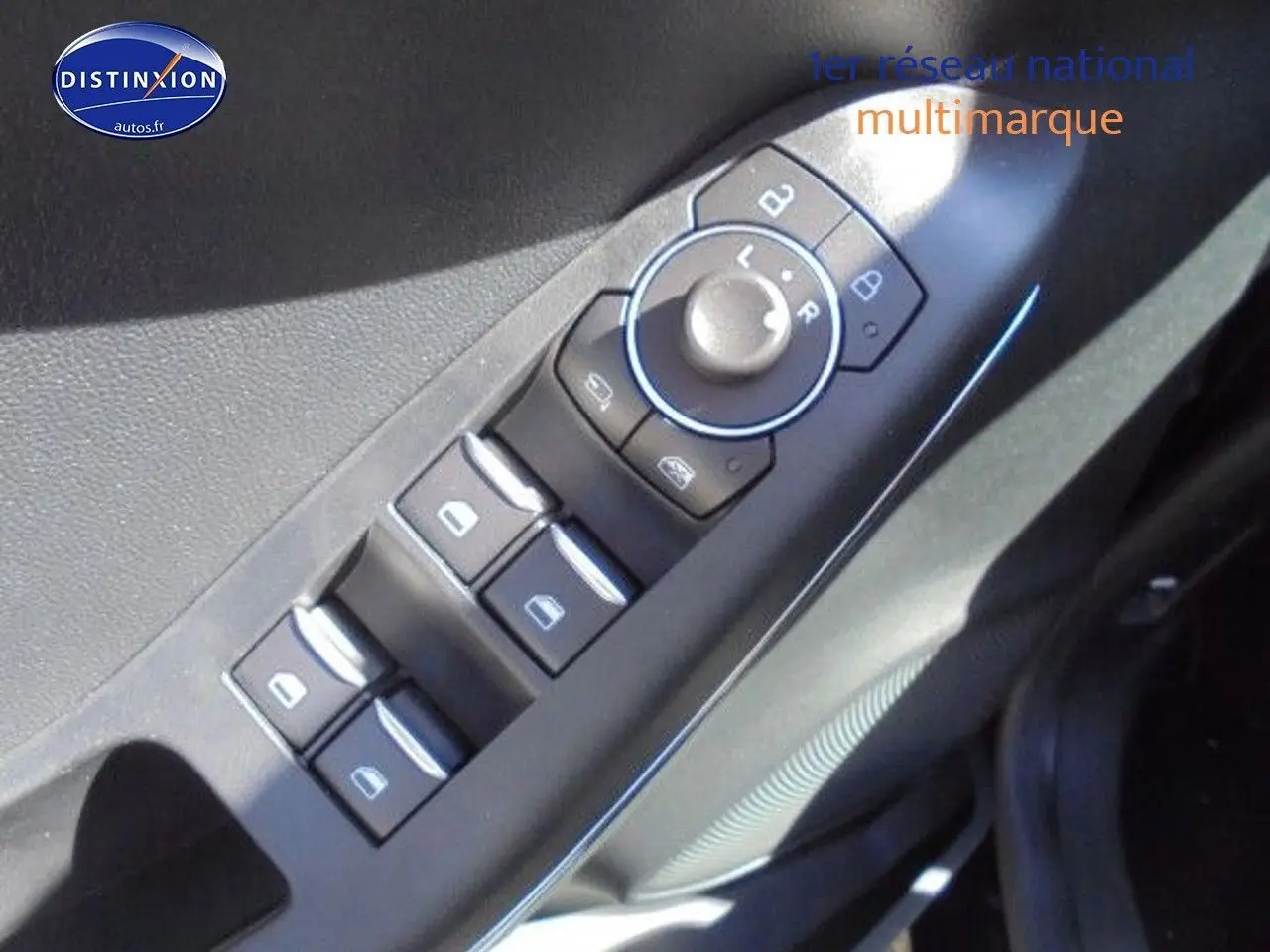 Gros plan sur les commandes des vitres et rétroviseurs côté gauche de la porte d'une Ford Puma noire 2022.