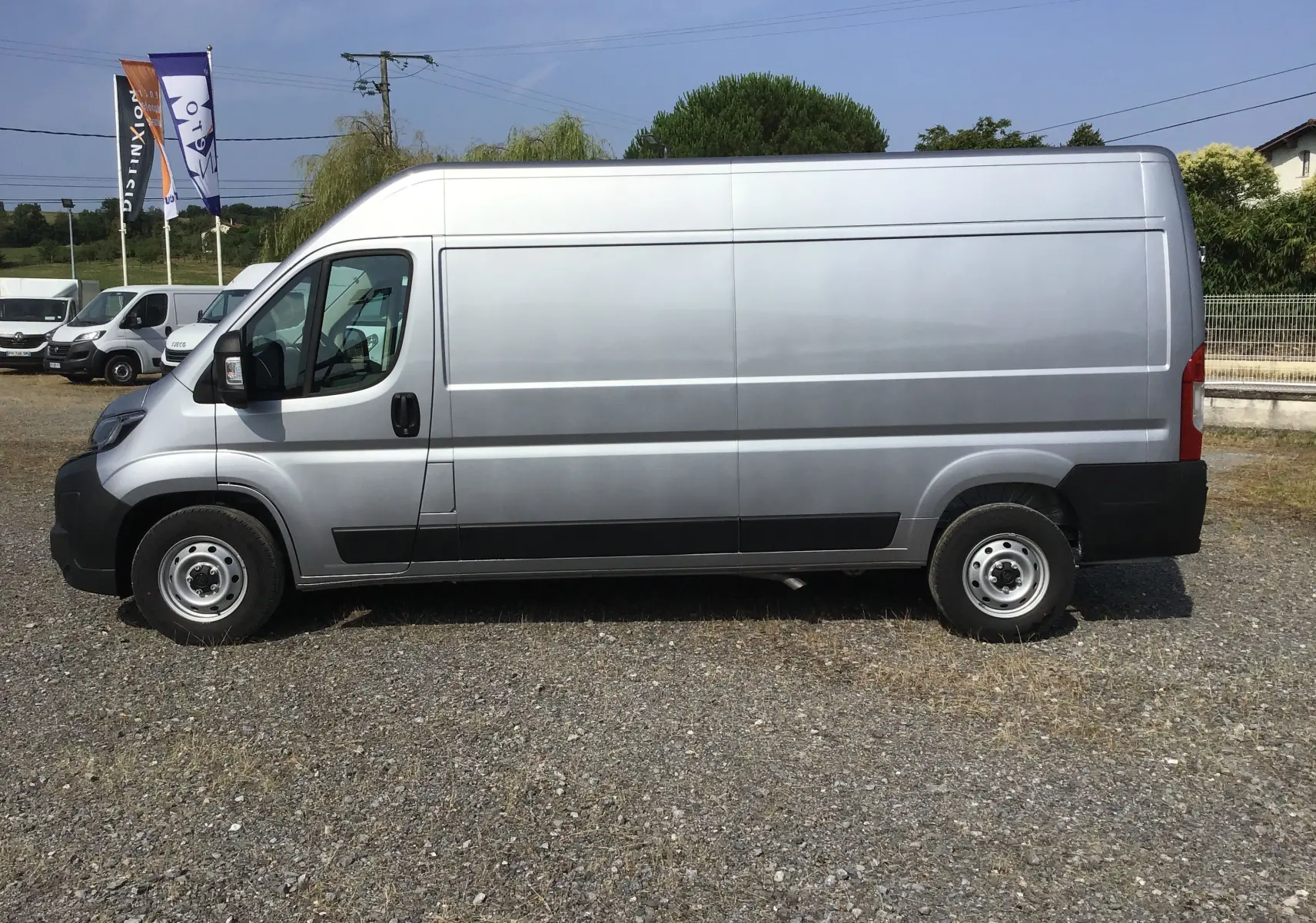 Peugeot Boxer Fourgon gris Artense vu de profil côté gauche, avec une carrosserie longue et haute sans fenêtres latérales.