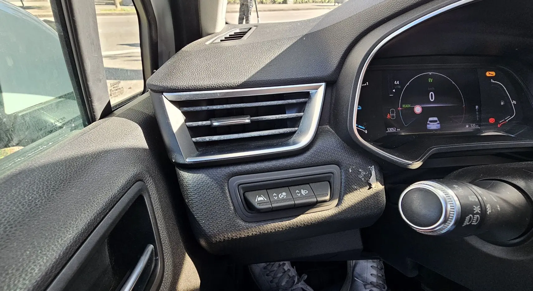 Détail du tableau de bord côté gauche de la Renault Clio blanche, avec commandes d'aide à la conduite et compteur numérique.