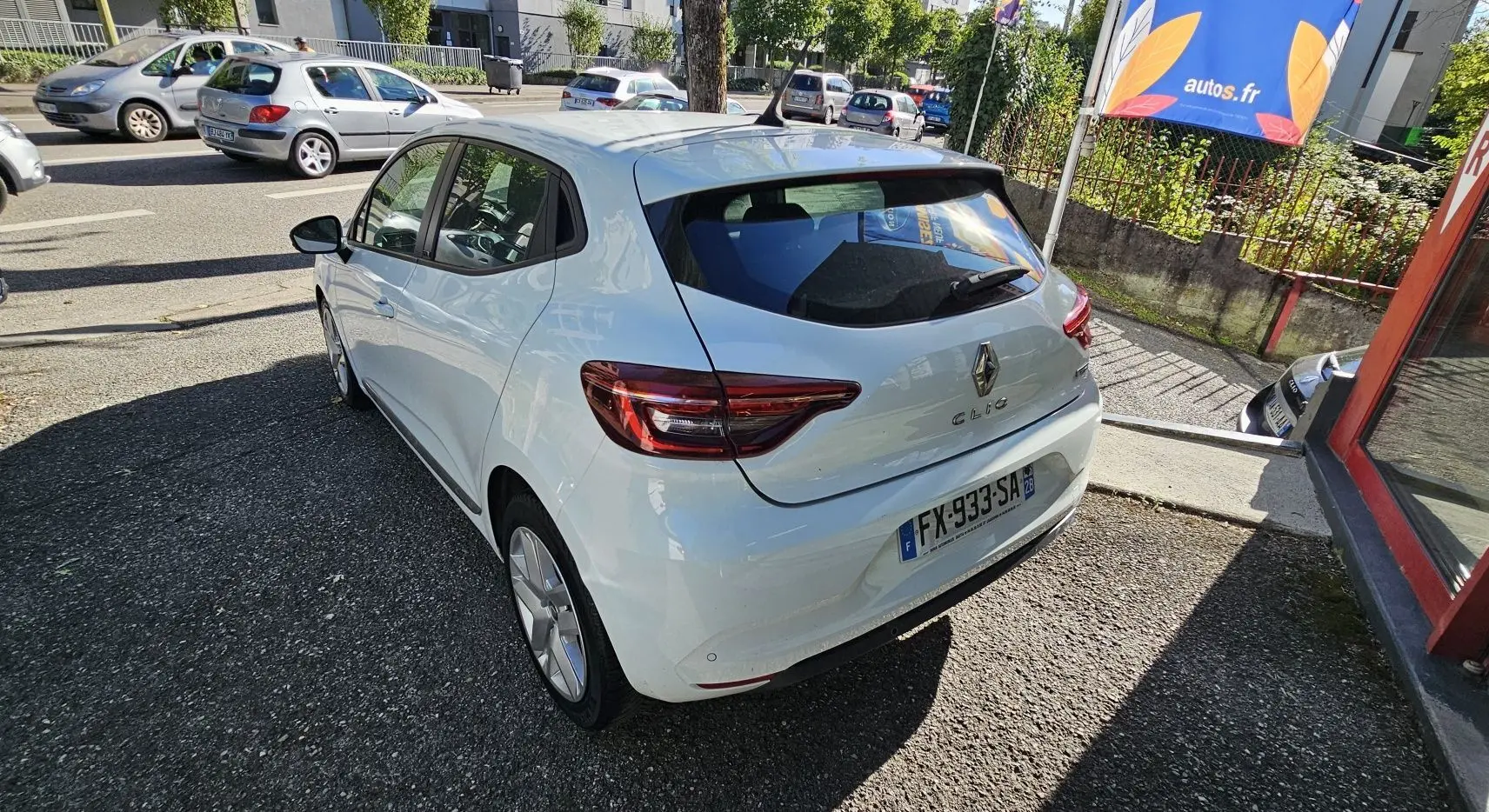 Vue 3/4 arrière droite d'une Renault Clio blanche Glacier hybride 2021 avec feux arrière LED et cinq portes.