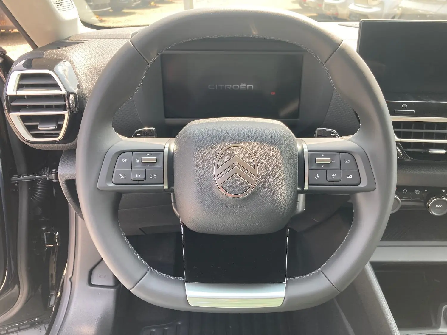 Volant cuir noir de la Citroën C4 Facelift Hybrid 145 e-DSC6 Max avec commandes intégrées et tableau de bord numérique.