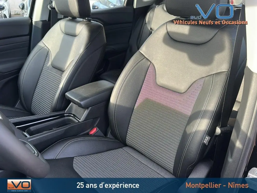 Gros plan sur les sièges avant en cuir noir du Jeep Compass 2024 avec accoudoir central et finitions soignées.