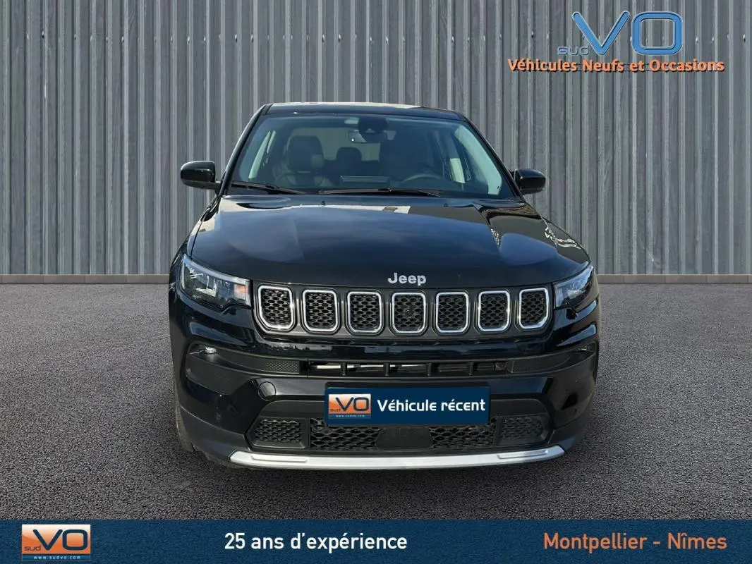 Vue frontale d'un Jeep Compass noir 2024 avec calandre à sept fentes et phares LED allumés.