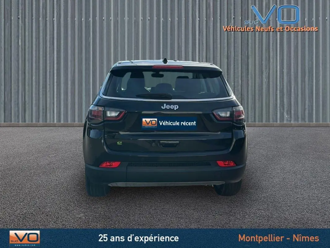 Vue arrière d'un Jeep Compass noir 2024 avec feux LED et logo Jeep bien visibles sur fond urbain.