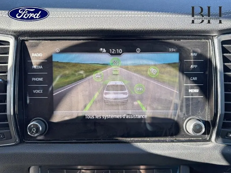 Écran tactile du tableau de bord montrant l’assistance à la conduite avec une voiture blanche sur une route droite