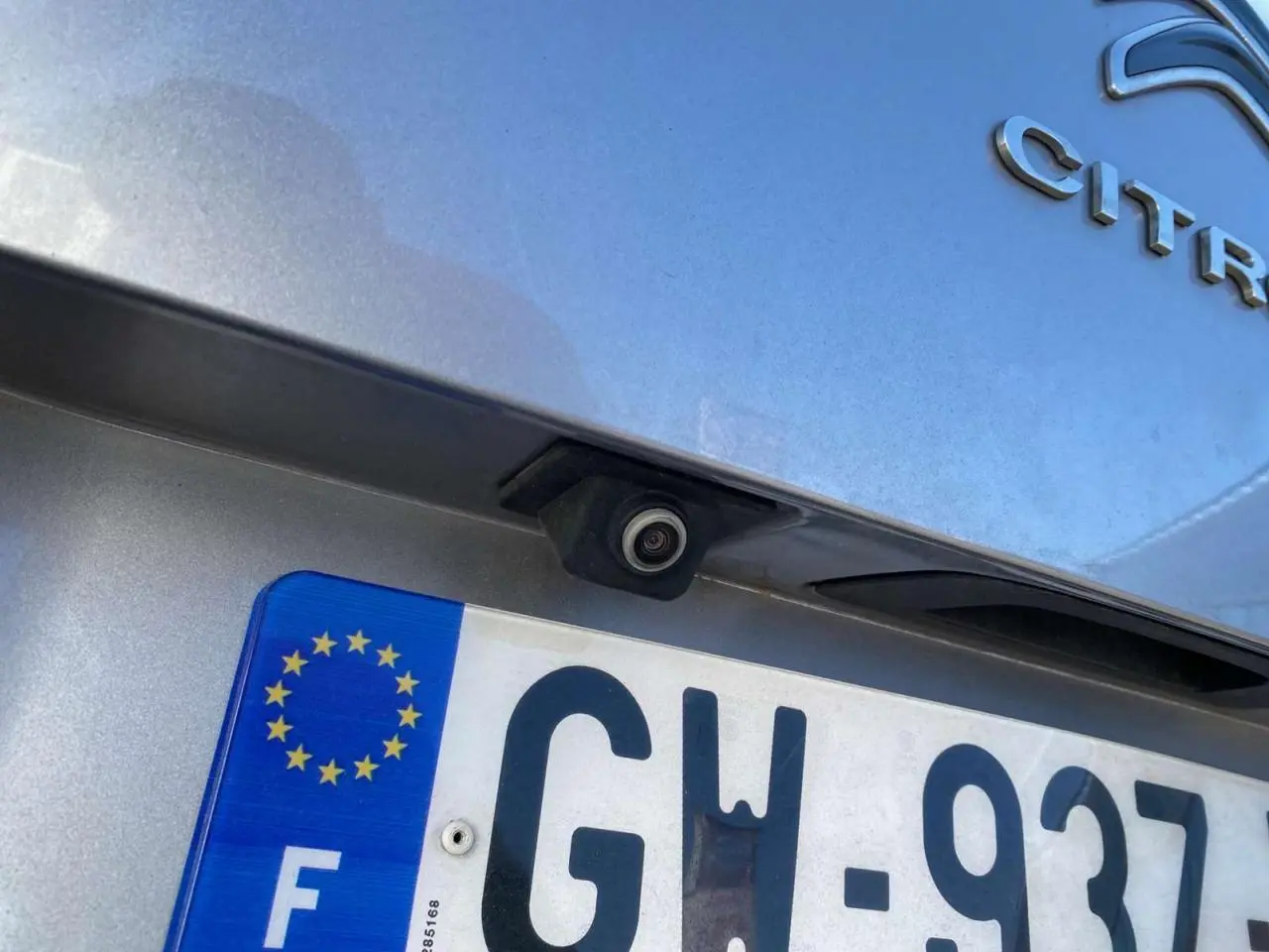Gros plan sur la caméra de recul au-dessus de la plaque d’immatriculation d’un Citroën C3 Aircross gris foncé.