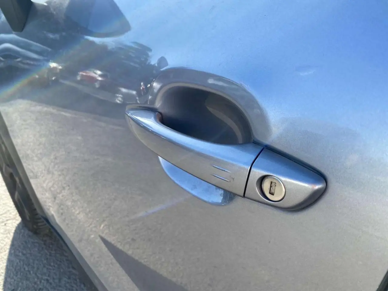 Poignée de porte côté gauche en gros plan sur Citroën C3 Aircross gris foncé 2024, finition avec serrure visible.