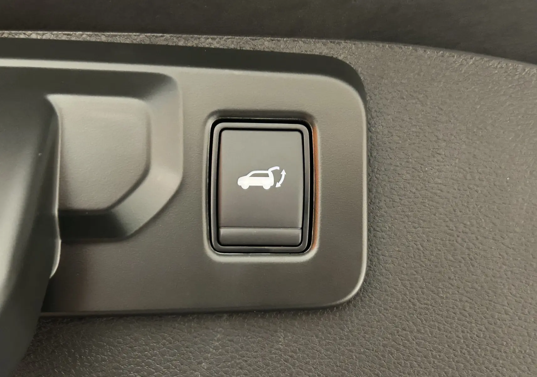 Bouton de commande du hayon électrique sur panneau intérieur noir du Renault Austral Ph.2 E-TECH full hybrid 200.