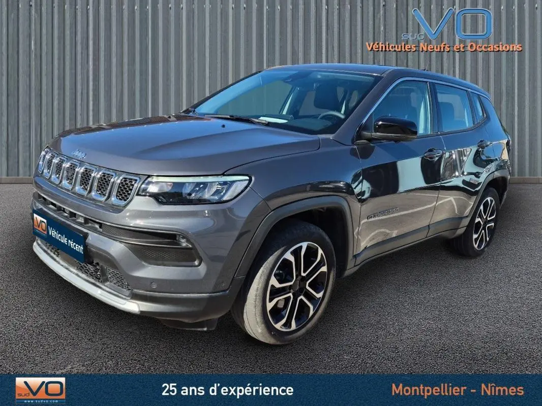 Jeep Compass gris en vue 3/4 avant droit, avec jantes alliage 18 pouces et calandre distinctive à sept fentes.