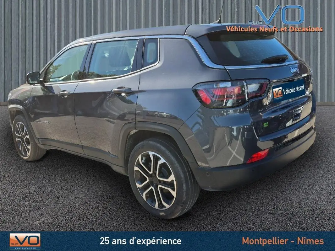 Vue 3/4 arrière droit d'un Jeep Compass gris 2024 avec jantes alliage 18 pouces et vitres teintées.