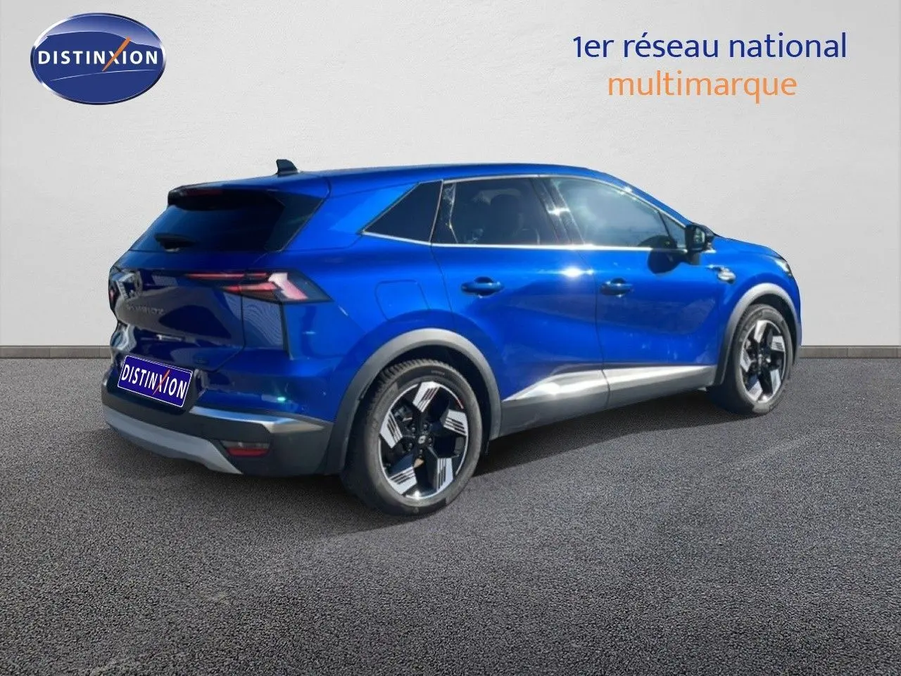 Vue 3/4 arrière droite du Renault Symbioz 2025 en bleu Iron Metal avec jantes bicolores et lignes modernes.