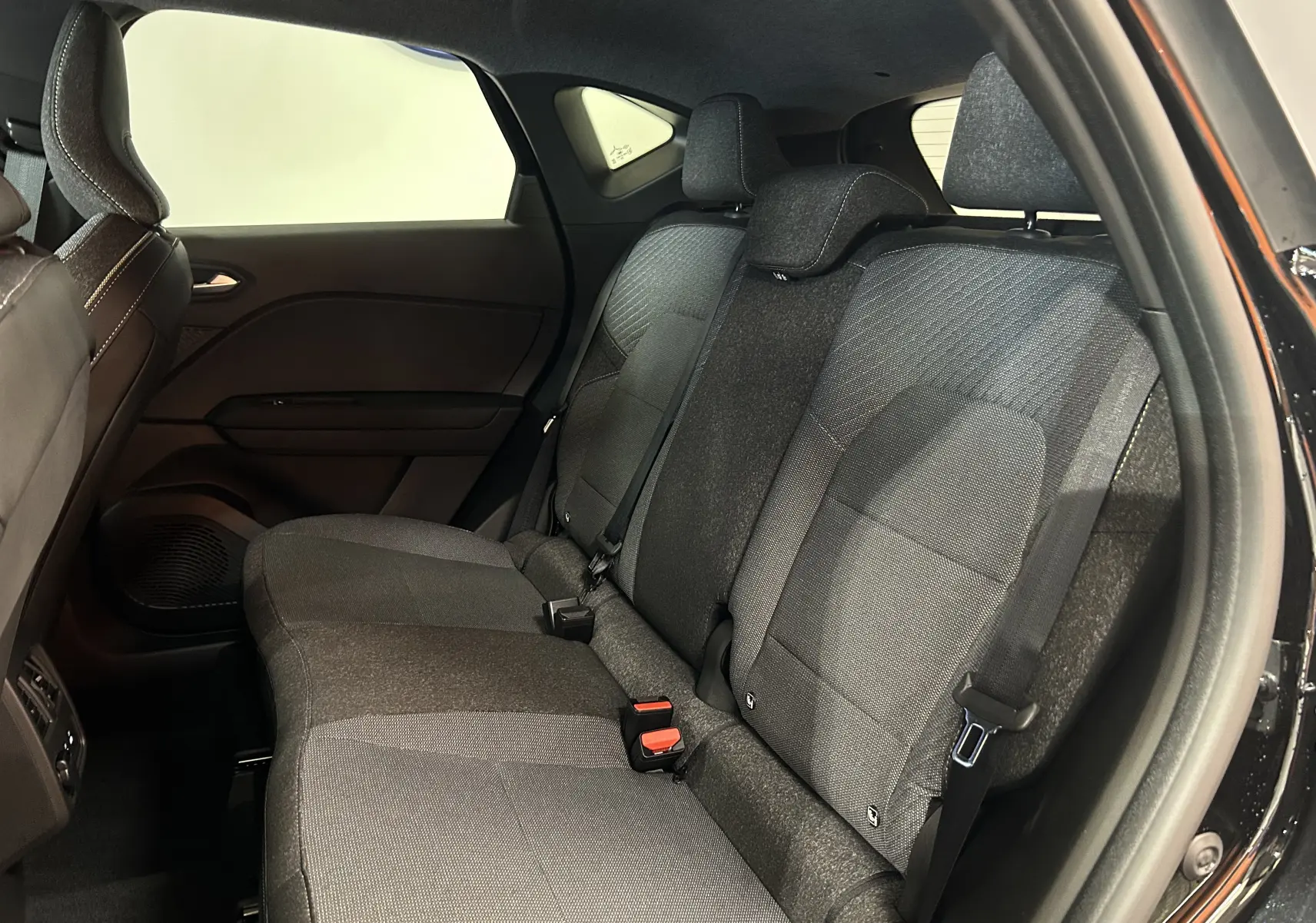 Vue intérieure côté droit des sièges arrière en tissu gris du Renault Captur II Ph.2 TECHNO noir étoilé 2025.