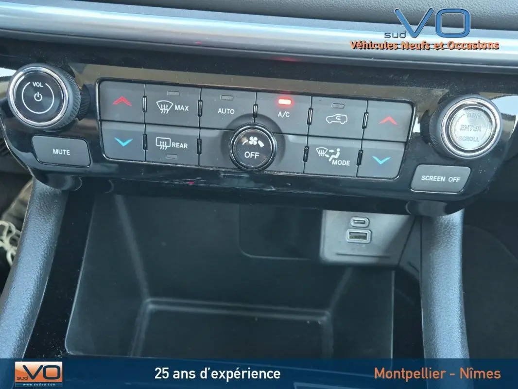 Vue rapprochée de la console centrale du Jeep Compass 2024, montrant les commandes de climatisation et ports USB.