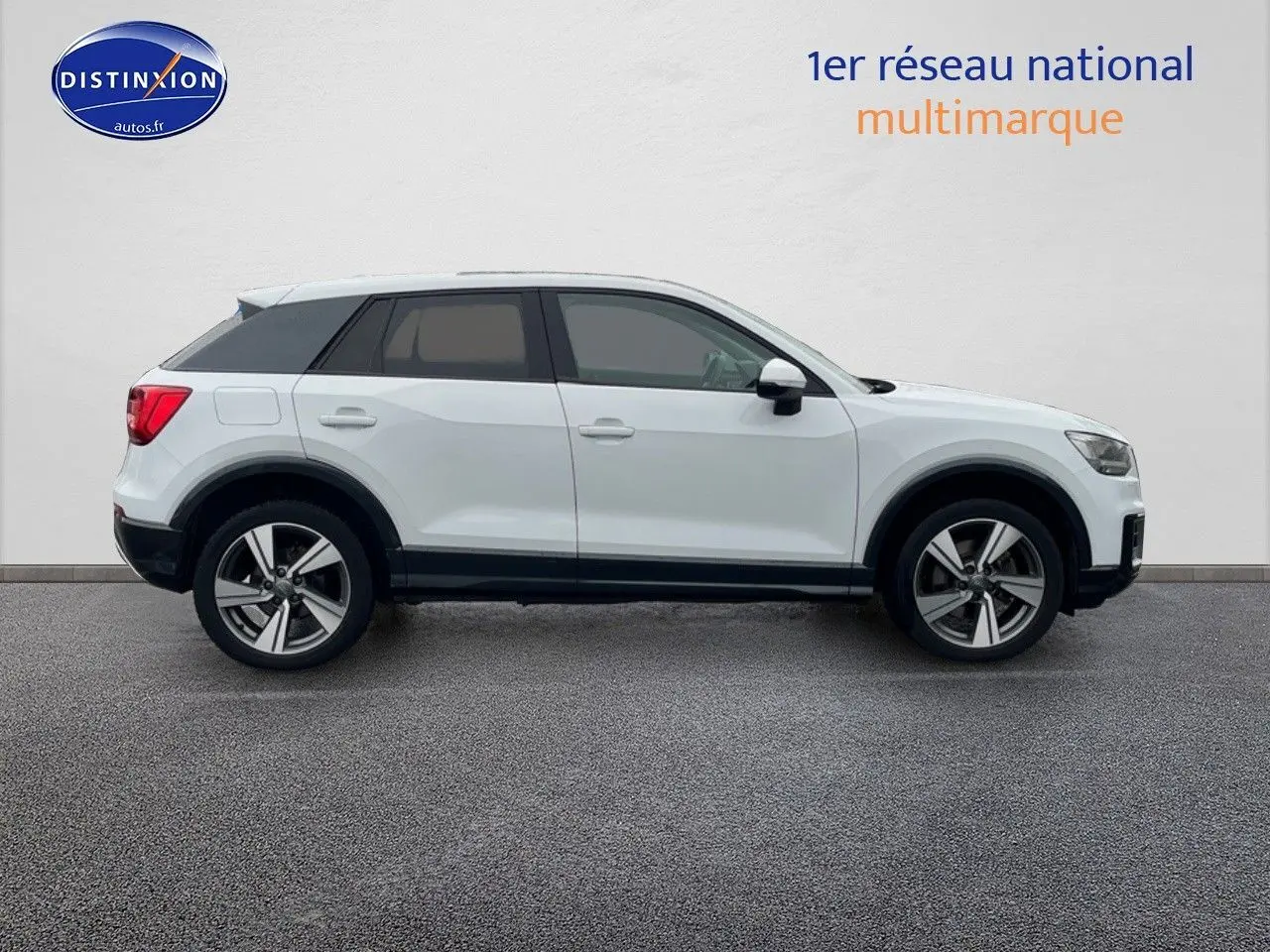 Profil droit d'un Audi Q2 blanc Ibis 2018 avec jantes 18 pouces et vitres surteintées.