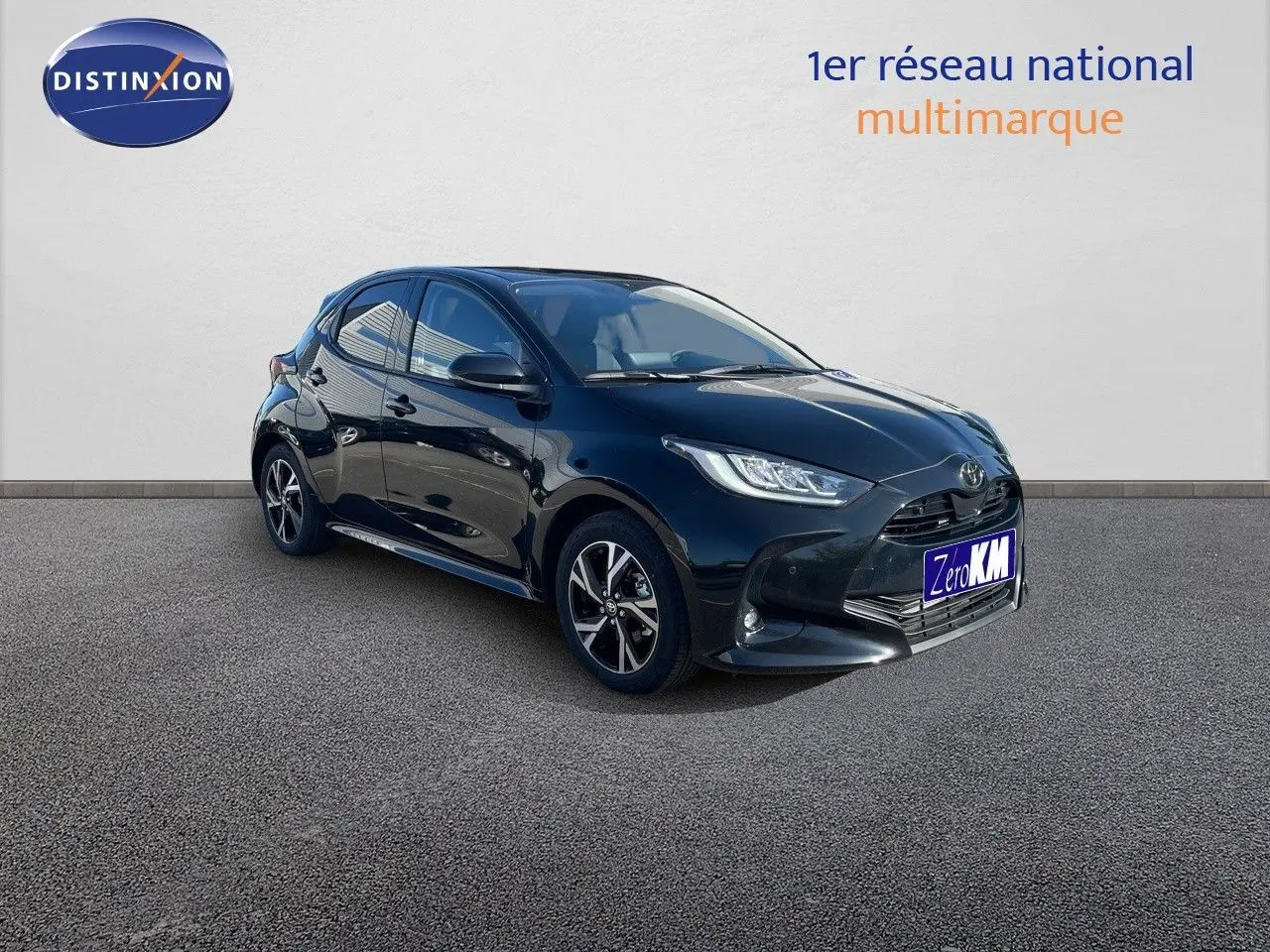 Toyota Yaris Hybrid 2025 noir métal vue 3/4 avant côté gauche avec jantes bi-ton et phares LED allumés.