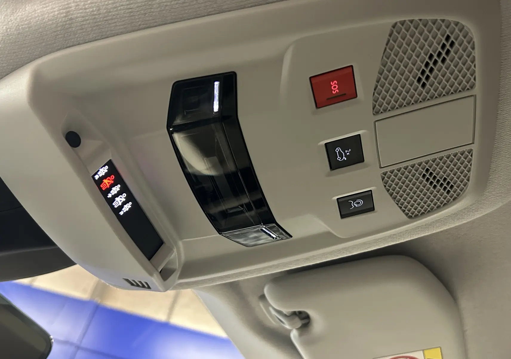 Vue en gros plan du plafonnier gris clair de la Fiat 600 Hybrid 2024 avec boutons SOS et ouverture hayon.