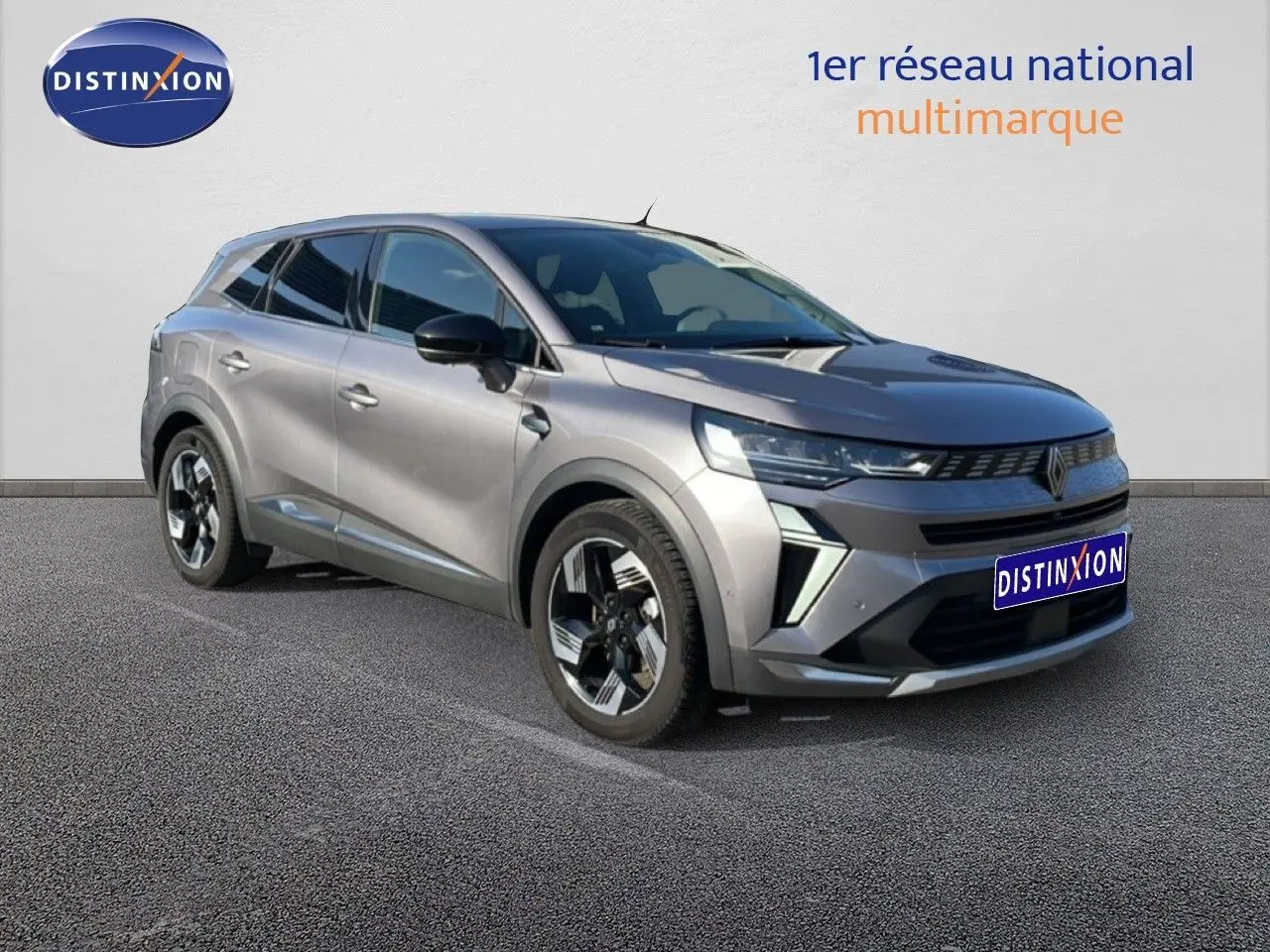 Renault Symbioz gris cassiopée métal en 3/4 avant droit, avec calandre distinctive et jantes bicolores.