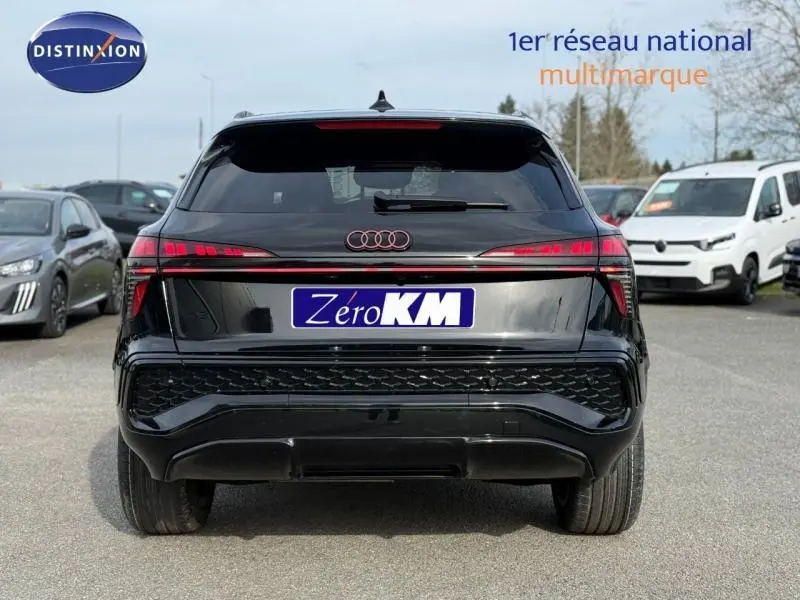 Vue arrière d'un Audi Q3 2.0 TDI 150ch S line 2026 en noir Mythique métallisé avec feux LED distinctifs allumés.