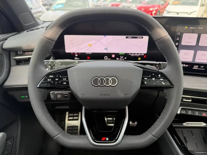 Vue intérieure centrée sur le volant multifonction noir de l'Audi Q3 2.0 TDI S line avec tableau de bord numérique.