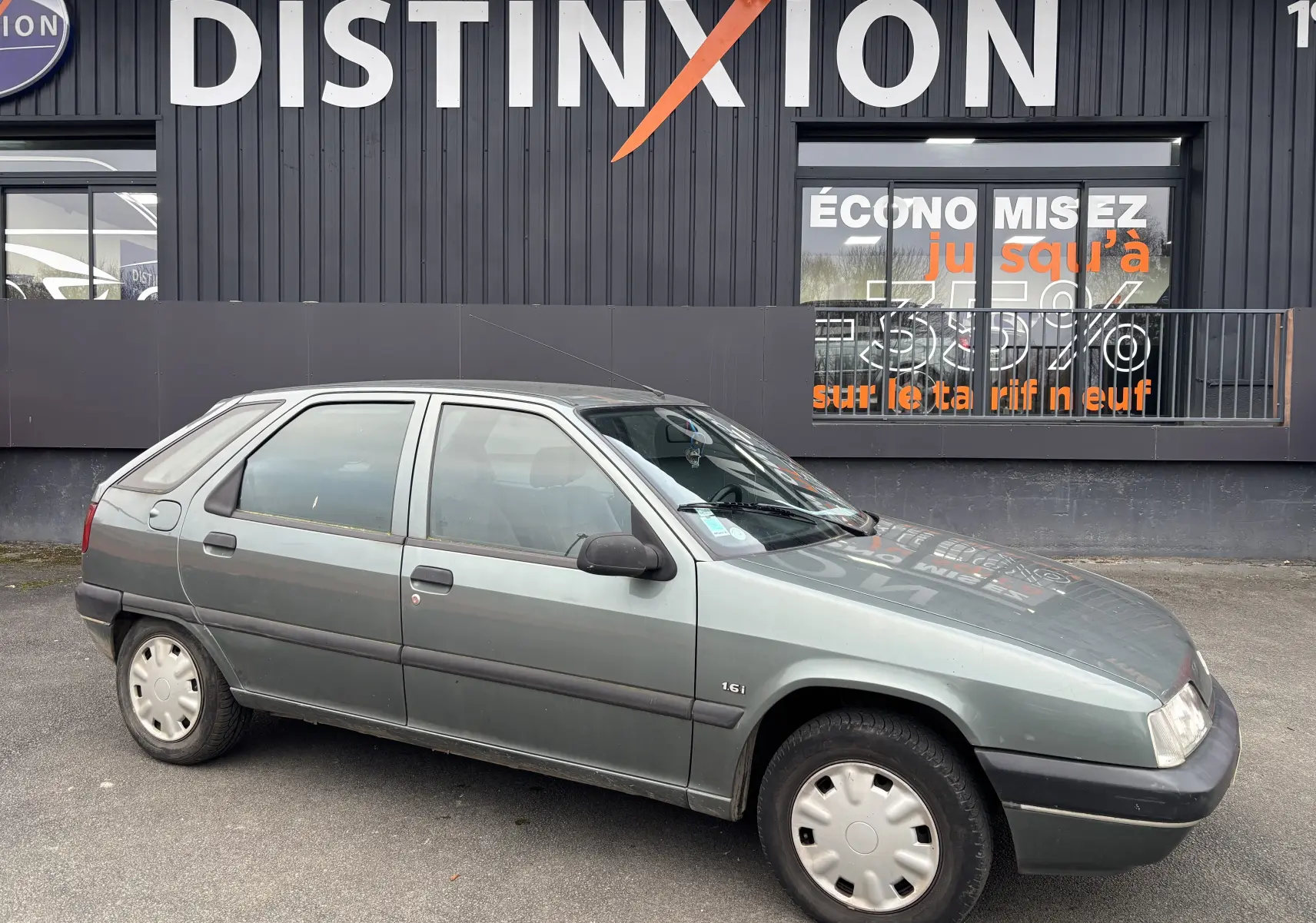 Citroën ZX gris vue de profil côté gauche, modèle 1.6i 89CV de 1992 avec jantes d'origine et carrosserie hatchback.