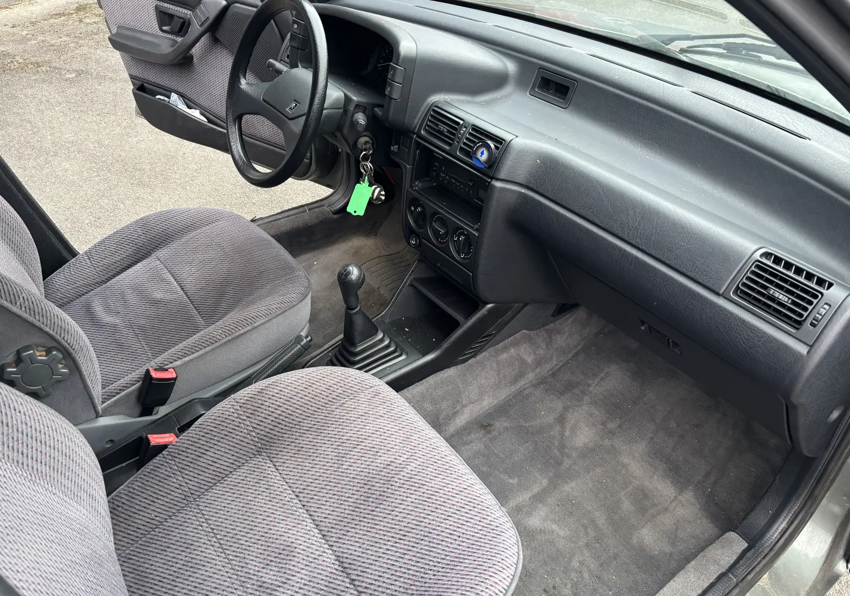 Intérieur avant droit d'une Citroën ZX 1.6i gris de 1992 avec sièges tissu et boîte manuelle à 5 vitesses.