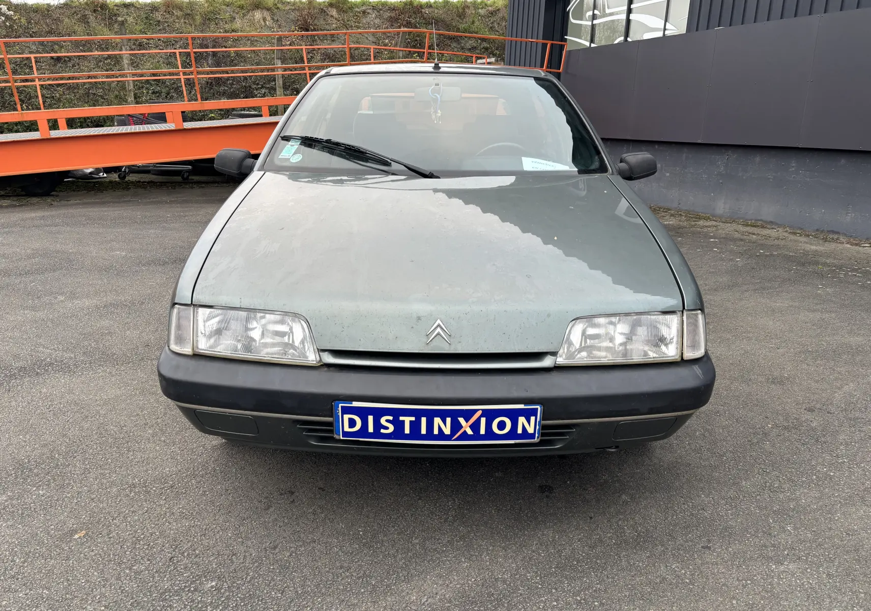 Vue frontale d'une Citroën ZX gris 1992 avec phares rectangulaires et plaque d'immatriculation Distinxion.
