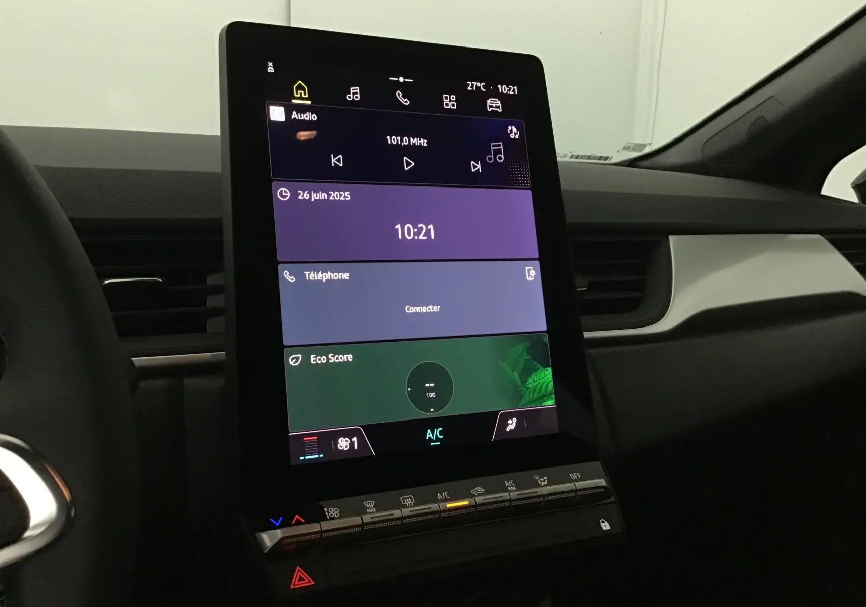 Écran tactile vertical du tableau de bord du Renault Captur 2025, avec commandes climatisation et interface multimédia visible.