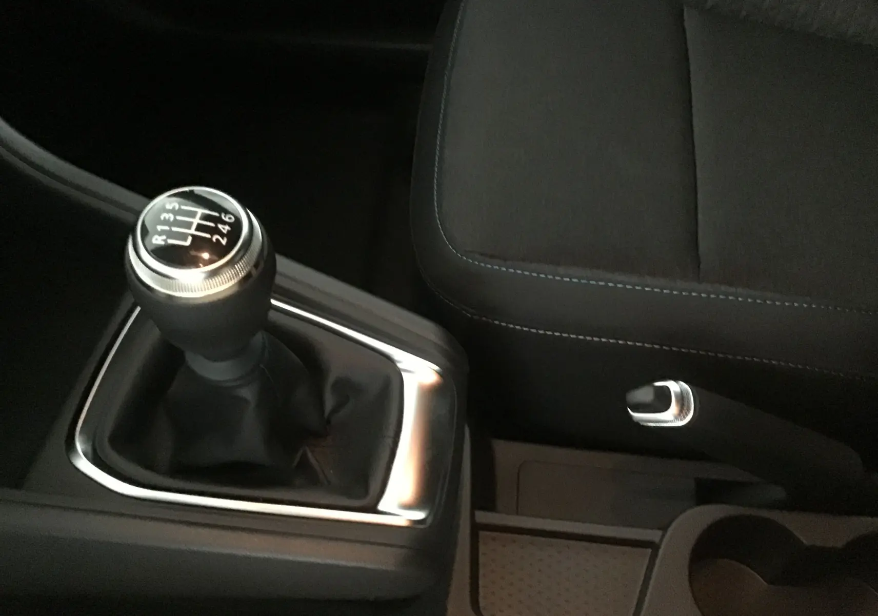 Le levier de vitesses manuel et le frein à main du Renault Captur gris rafale/ noir vus de près dans l'habitacle.