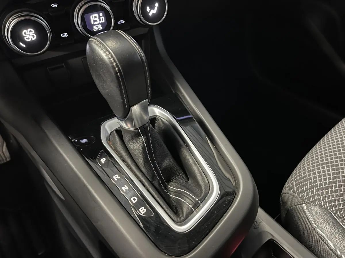 Le levier de vitesses automatique en cuir noir de la Renault Arkana 1.6 E-Tech Hybride, vue rapprochée de la console centrale.