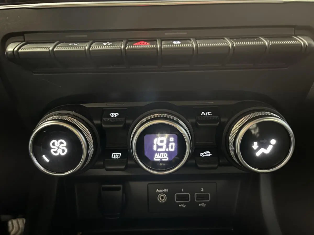 Commandes de climatisation automatique avec affichage digital et ports USB dans l'habitacle noir du Renault Arkana 2021.