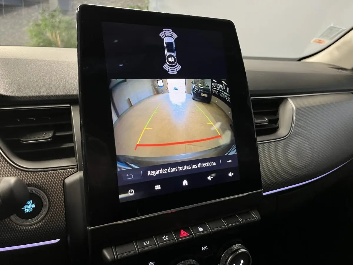 Écran tactile vertical affichant la caméra de recul dans l'habitacle noir du Renault Arkana 1.6 E-Tech Hybride.