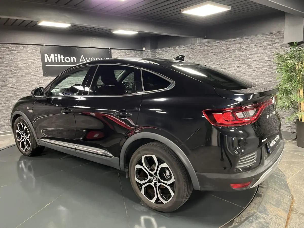 Vue 3/4 arrière droite d'une Renault Arkana noire avec jantes alliage noires et feux arrière LED distinctifs.