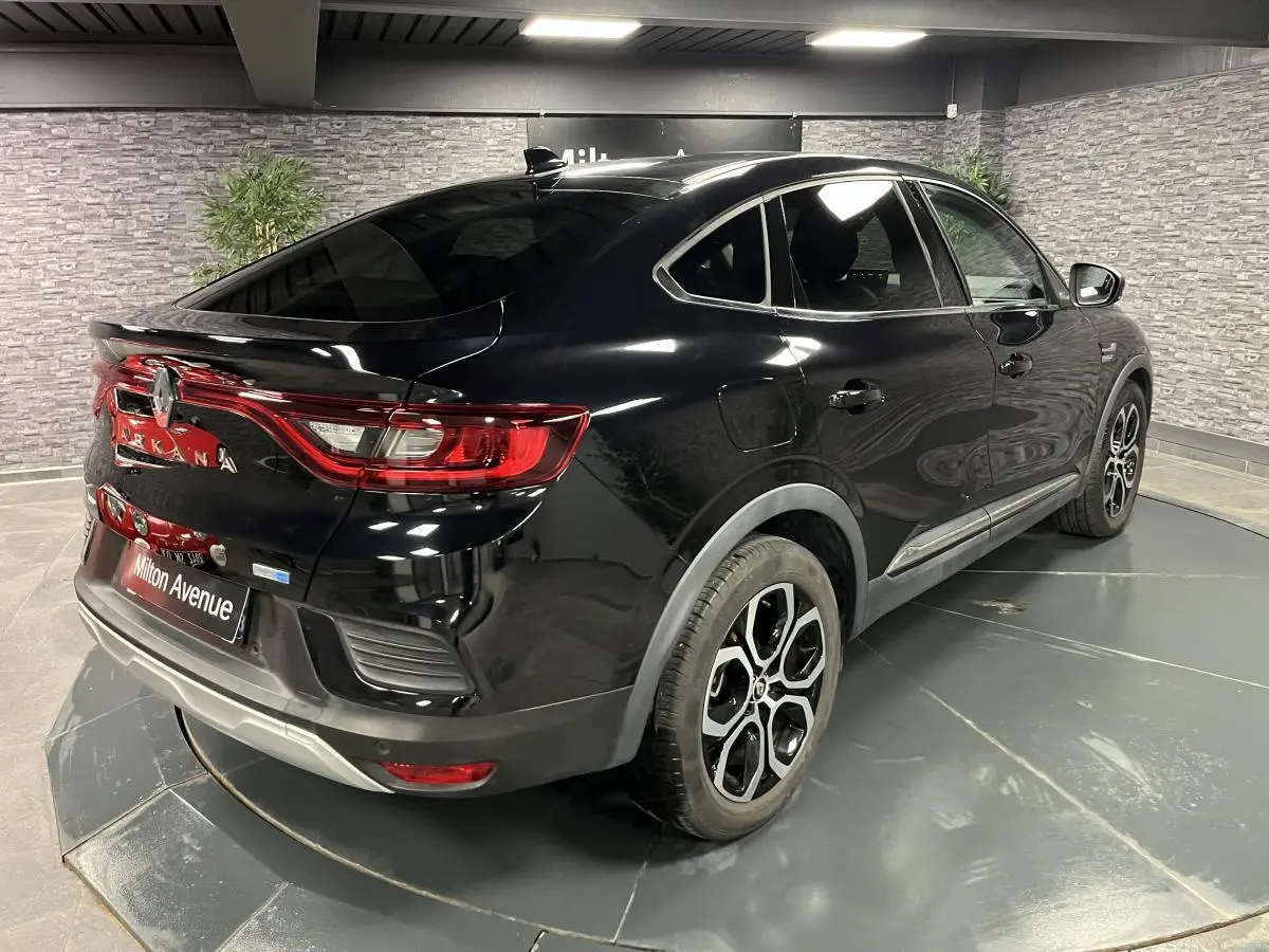 Renault Arkana noir métal vu en 3/4 arrière droit, avec jantes alliage noires et feux arrière LED distinctifs.