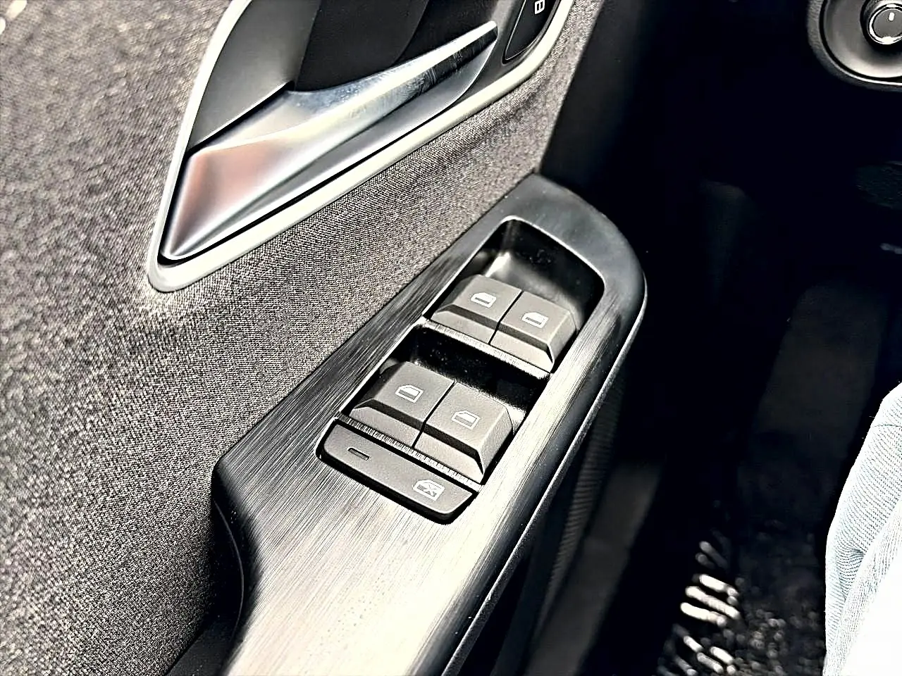 Détail des commandes des vitres électriques côté conducteur dans l’habitacle du MG Motor ZS hybride Camden grey.