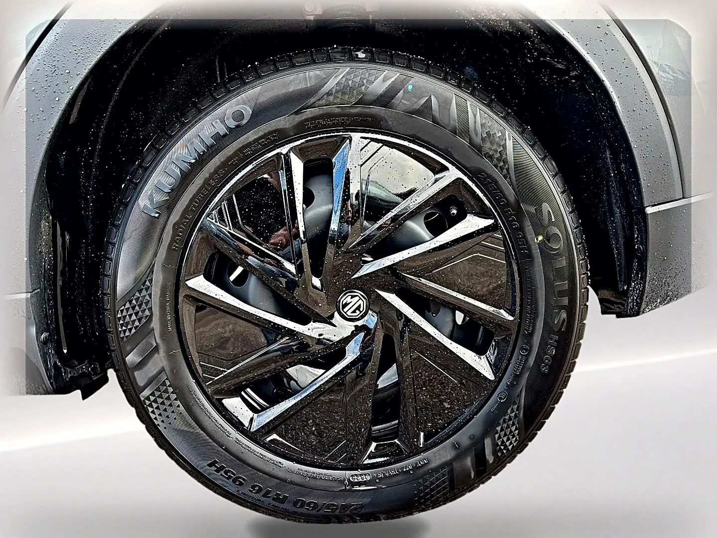 Gros plan sur la roue avant droite du MG ZS Camden grey, mettant en valeur la jante noire brillante au design moderne.